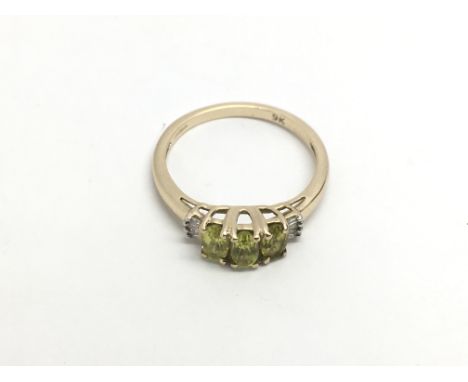 A 9ct gold ring set with green stones, approx 1.9g and approx size N.