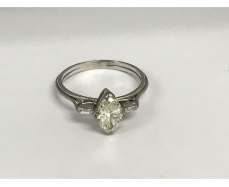A unmarked white gold ring inset with an Marquise diamond flanked by smaller diamond. Size R .