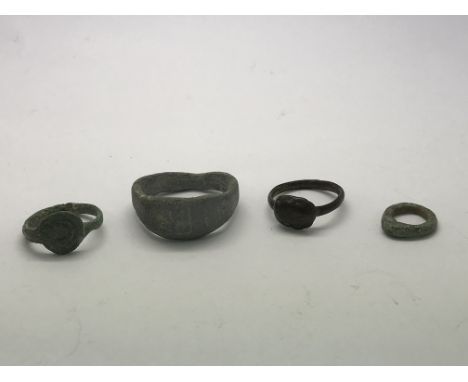 An ancient Roman ring with a swastika engraved on the bezel, as well as three other ancient rings from the Roman period.