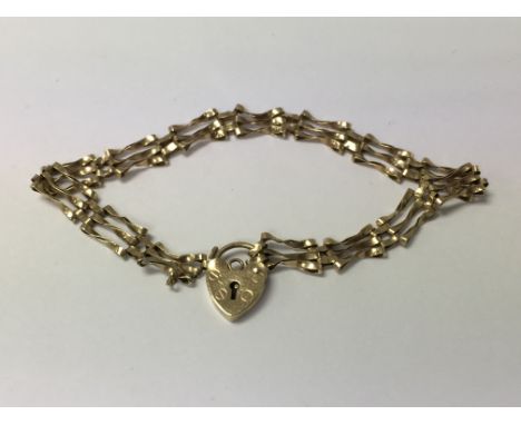 A late 20th century 9ct gold gate link heart padlock bracelet, maker's marks ASJ, hallmarks London. Weighing approximately 3.
