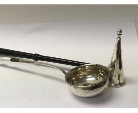 A Georgian silver toddy ladle with a whale bone handle inset with a George II coin and a silver candle snuffer (2)