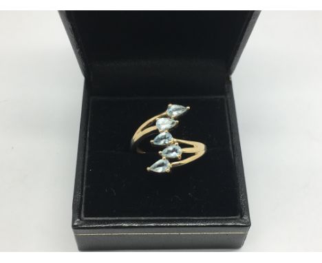 A 9ct gold ring set with five pale blue stones, possibly tanzanite, approx 3.6g and approx size L.