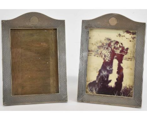 A pair of George V hallmarked silver matching tabletop photograph frames, each with dome top, blank circular panel and engine