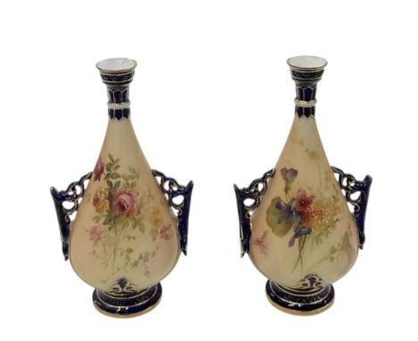 ROYAL WORCESTER; a pair of blush ivory hand painted cobalt blue and gilt decorated twin handled narrow neck vases, both heigh