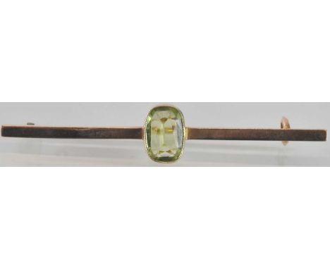 A 9ct gold bar brooch, with cushion cut bezel set peridot, length 5.4cm, approx 3g.