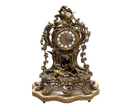 A modern gilt metal figural mantel clock on marble base, decorated with cherubs and animals, the dial set with Roman numerals