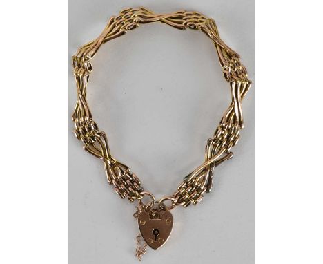 A 9ct rose gold four bar gate link bracelet with crossover links, united by a 9ct gold heart shaped padlock clasp, length 19c