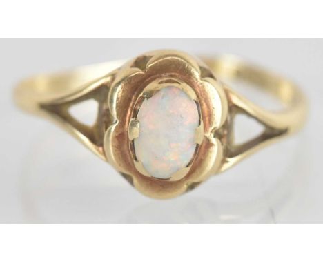 A 9ct yellow gold opal set ring, the central opal approx 0.4ct, size Q, approx 1.6g.