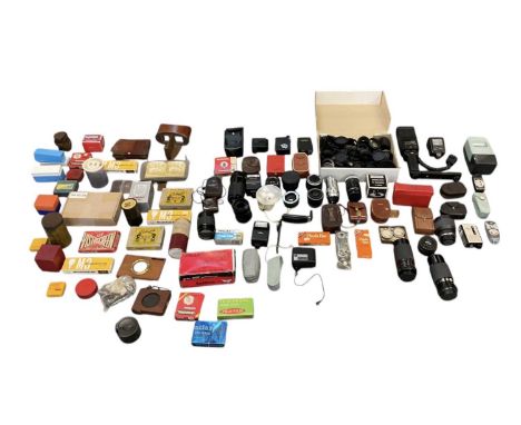 A large group of camera equipment including lenses, mounts, covers, range finders, light meters, flash guns, film slides, ant
