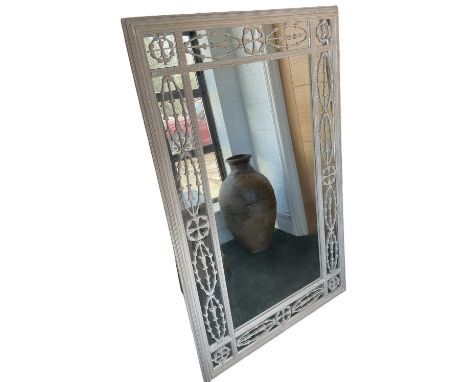 A modern French style white painted rectangular wall mirror, the frame set with carved fretwork above mirrored panels, 155 x 