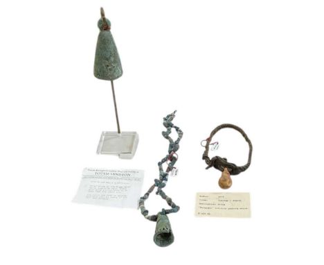 Two excavation bells originating in the Niger River of Mali, one with bone bead necklace adornment, a goat skin neckpiece and