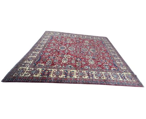 A large modern red ground Kazak carpet, decorated with flowers and medallions, 515 x 414cm.