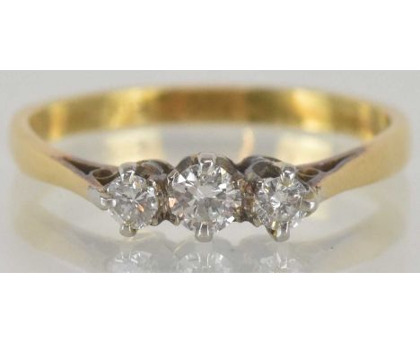 An 18ct yellow gold diamond set three stone ring, the central round brilliant cut diamond approx 0.15ct, flanked by a pair of