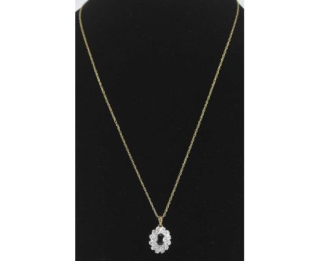 A 9ct white gold sapphire and diamond set pendant, the central raised claw set sapphire within swirls of tiny diamond chips, 