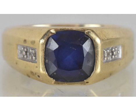 A 9ct yellow gold sapphire and diamond set signet ring, the central simulated sapphire approx 2ct, flanked by two small illus