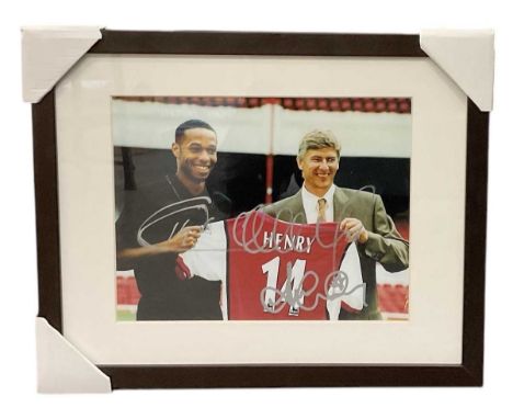 A coloured framed photograph of Arsène Wenger presenting Thierry Henry with a football shirt, bearing two signatures to the f