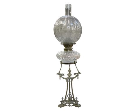An early 20th century brass oil lamp, with clear cut glass well and clear floral decorated glass shade, height 70.5cm.Conditi