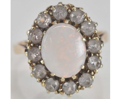 A 9ct gold dress ring, with oval white opal to the centre, within a border of small cubic zirconia stones, size Q, approx 4.5