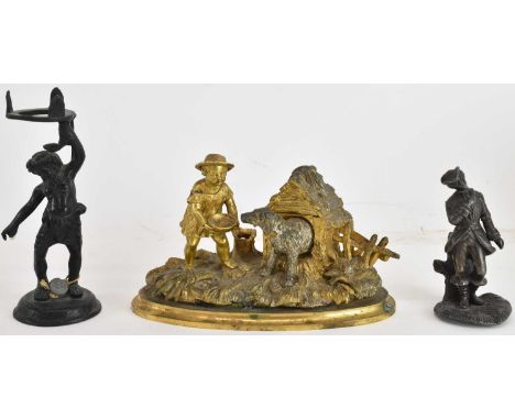 A novelty gilt metal inkwell modelled as a dog emerging from a kennel, with porcelain liner, a tree stump acting as a pen hol