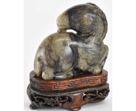 An early 20th century carved pale grey and black jade figure of a ram, raised on modern carved hardwood stand, height includi
