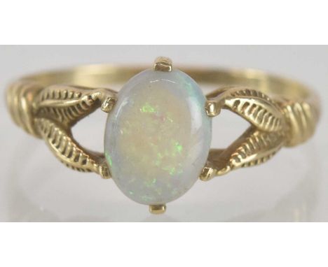 A 9ct gold opal ring, the oval opal with traces of green and blue, in a claw set mount with open naturalistic shoulders, size