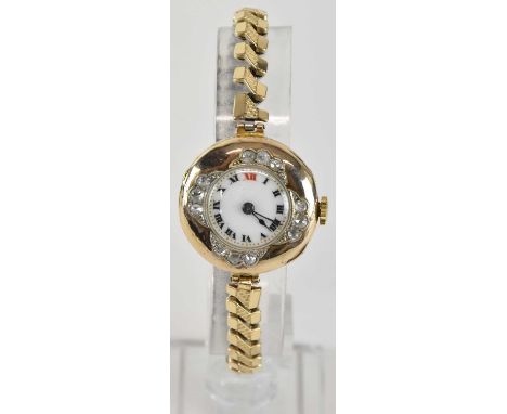 A lady's vintage 9ct gold diamond set wristwatch, the white enamel dial set with Roman numerals and red 12 o'clock, with crow