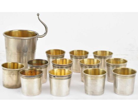 A set of twelve French white metal shot cups, inscribed 'Lapar of Paris', with Minerva mark, and a collapsible plated cup, wi