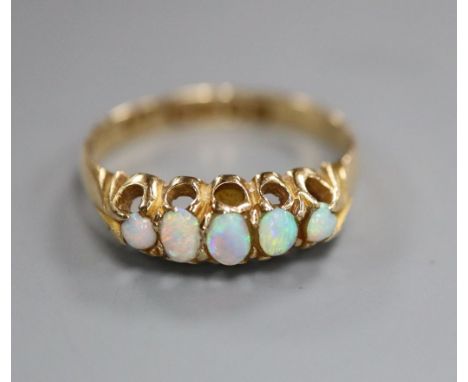 An Edwardian 18ct gold and graduated five stone white opal half hoop ring, size O.