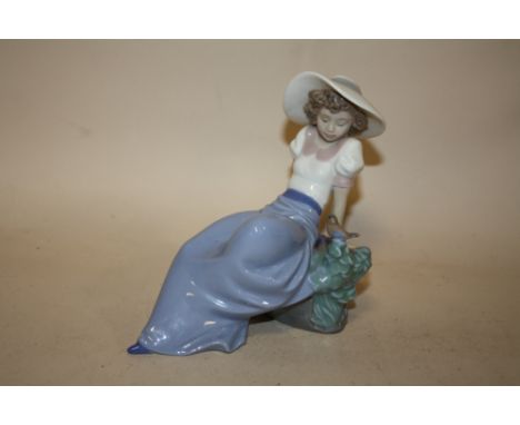 A NAO FIGURE OF A SEATED LADY WITH A BIRD