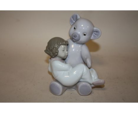 A NAO FIGURE OF A YOUNG GIRL ASLEEP WITH A TEDDY BEAR