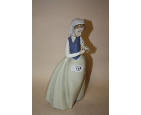 A NAO FIGURE OF A LADY HOLDING A BIRD
