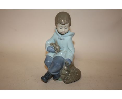 A NAO FIGURE OF A SEATED YOUNG BOY WITH A RABBIT