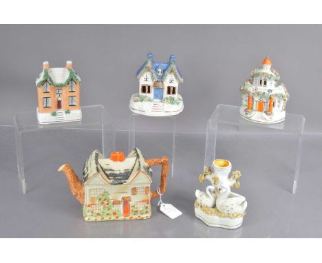 Five Staffordshire pottery items, including a house shaped money box, two house shaped pastille burners, a cottage shaped tea