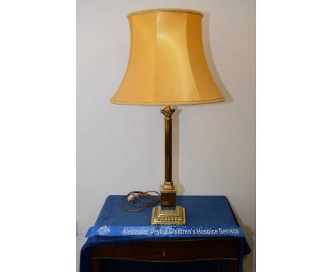 A late 20th century brass table lamp base, Corinthian column, readed on a stepped and ribbed base, with a mustard silk shade 