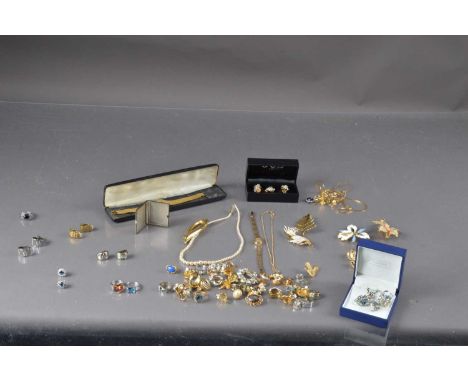 A collection of costume jewels, including brooches, clip earrings, silver three stone paste ring, simulated pearls, blue past
