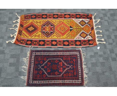 Two Oriental rugs including a Persian style Kilim and a smaller Turkish rug, the Kilim with a yellow and orange ground, the T