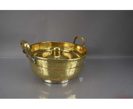 A Middle Eastern polished brass basin and cover, the basin with twin handles and chased decoration the cover or lid with piec
