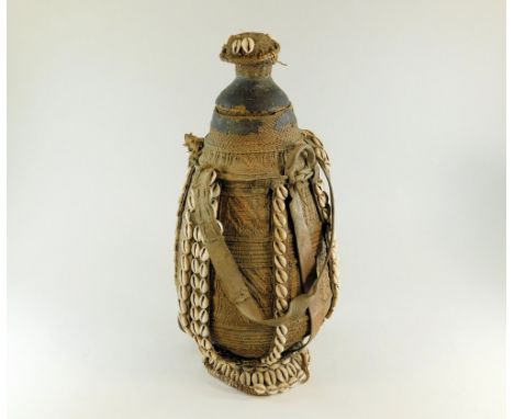 WATER CARRIER. An Ethiopian straw-work &amp; leather water carrier, decorated with cowrie shells. Height 48cm.