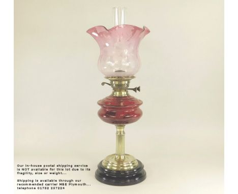 OIL LAMP. A Victorian oil lamp with ruby glass fount &amp; etched cranberry shade. Height 61cm. Please note: Our in-house pos