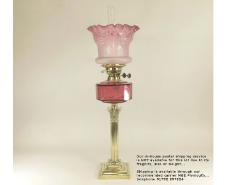 OIL LAMP. A Victorian classical column oil lamp with cranberry fount &amp; etched shade. Height 67cm. Please note: Our in-hou