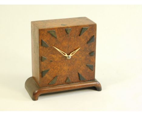 ART DECO CLOCK. A 1920's/30's Art Deco/Modernist 30 hour mantel clock, with mulberry veneered case, curved mahogany stand & e