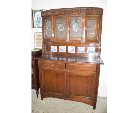A 20th Century dresser with glass and mirrored cupboards and Delft style tiles