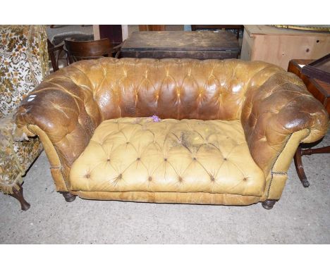 A vintage leather upholstered Chesterfield sofa, heavily worn condition with some rips to upholstery