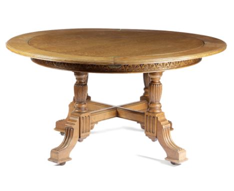 A LATE VICTORIAN OAK EXTENDING DINING TABLE BY W. WALKER &amp; SONS, C.1880-90 the circular moulded edge top with four brass 