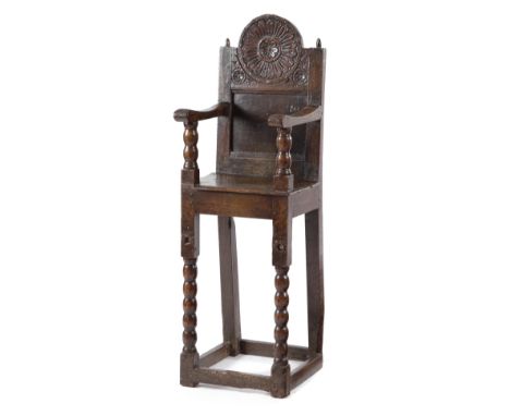 A LATE CHARLES II OAK CHILD'S HIGHCHAIR C.1680 the panelled back decorated with flowerhead rondels, on bobbin turned supports