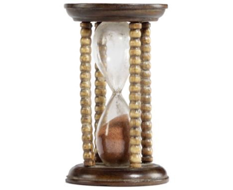 A SMALL EARLY VICTORIAN TREEN SAND GLASS C.1840-50 with bobbin turned supports and twin glass bulbs, it runs for approximatel