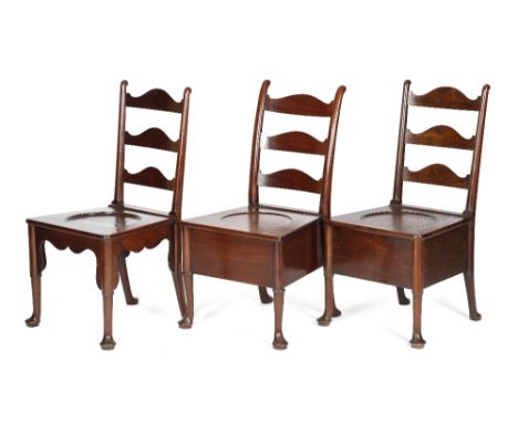 THREE GEORGE II MAHOGANY COMMODE CHAIRS C.1740-50 each with a shaped ladder back, above a dished seat, two hinged, on turned 