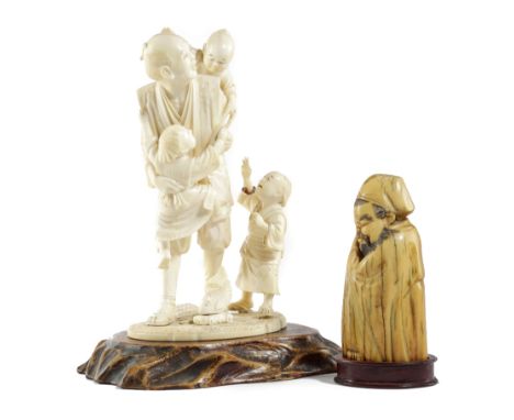 λ A JAPANESE IVORY OKIMONO GROUP OF A FARMER MEIJI 1868-1912 carved with three boys, two clambering over him, one with a toy 