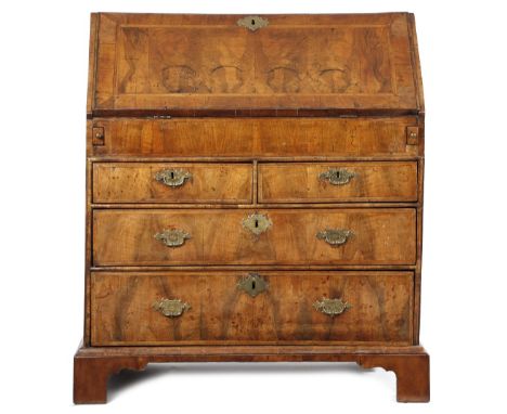 A GEORGE I WALNUT BUREAU C.1715 with cross and feather banding, the hinged fall revealing an interior with an arrangement of 