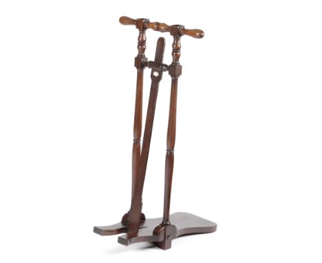 A MAHOGANY BOOT JACK with a turned handle and supports, with an applied ivorine plaque, inscribed 'Alan Mcafee 38 Dover St. L